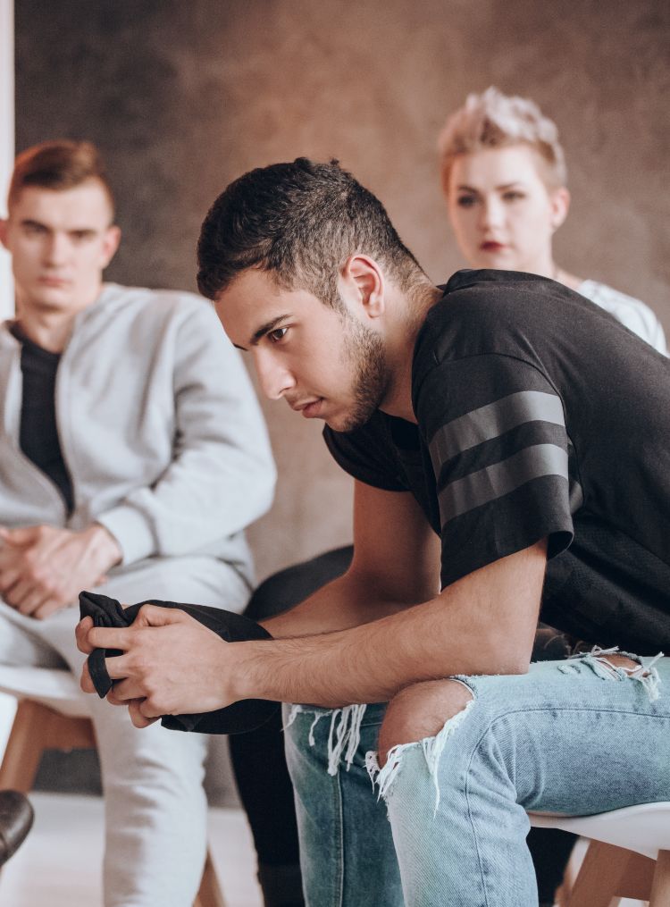 Angry rebellious teenager being analyzed by a counselor, psychotherapy concept