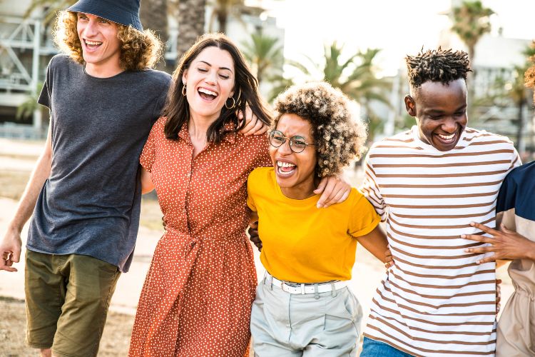 Young happy people laughing together  Multiracial friends group having fun on city street  Diverse culture students portrait celebrating outside  Friendship, community, youth, university concept