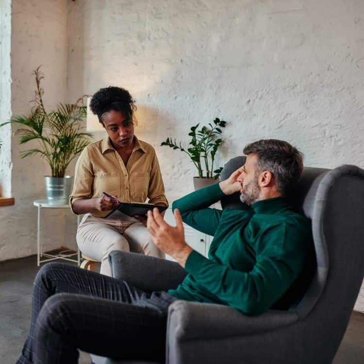 Middle age man discusses problems with a female mental health professional.