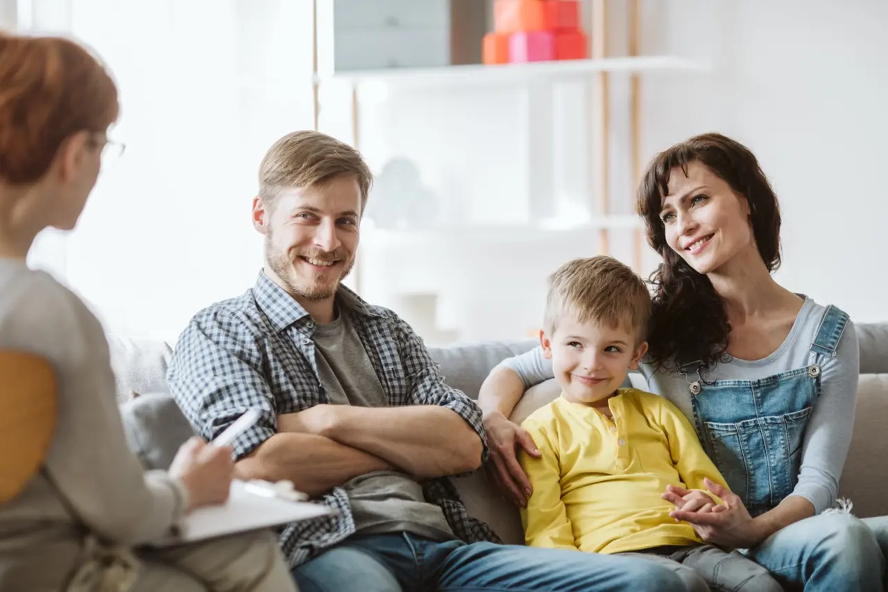 A family (mother, father, child) in a therapy session for their child's ADHD